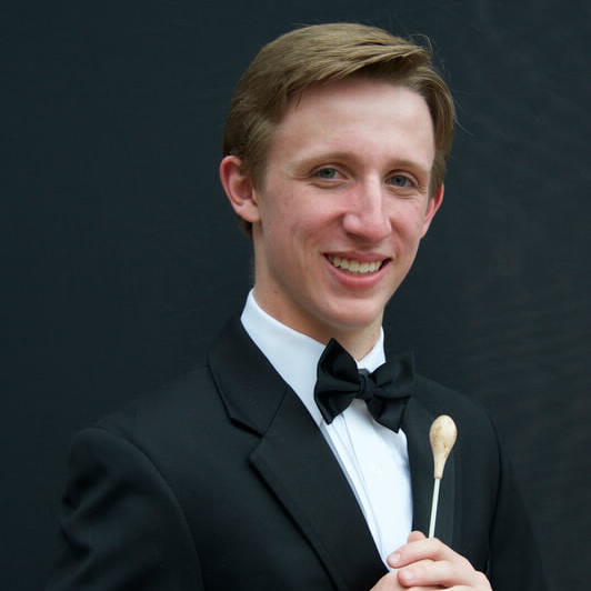 man smiling holding a baton